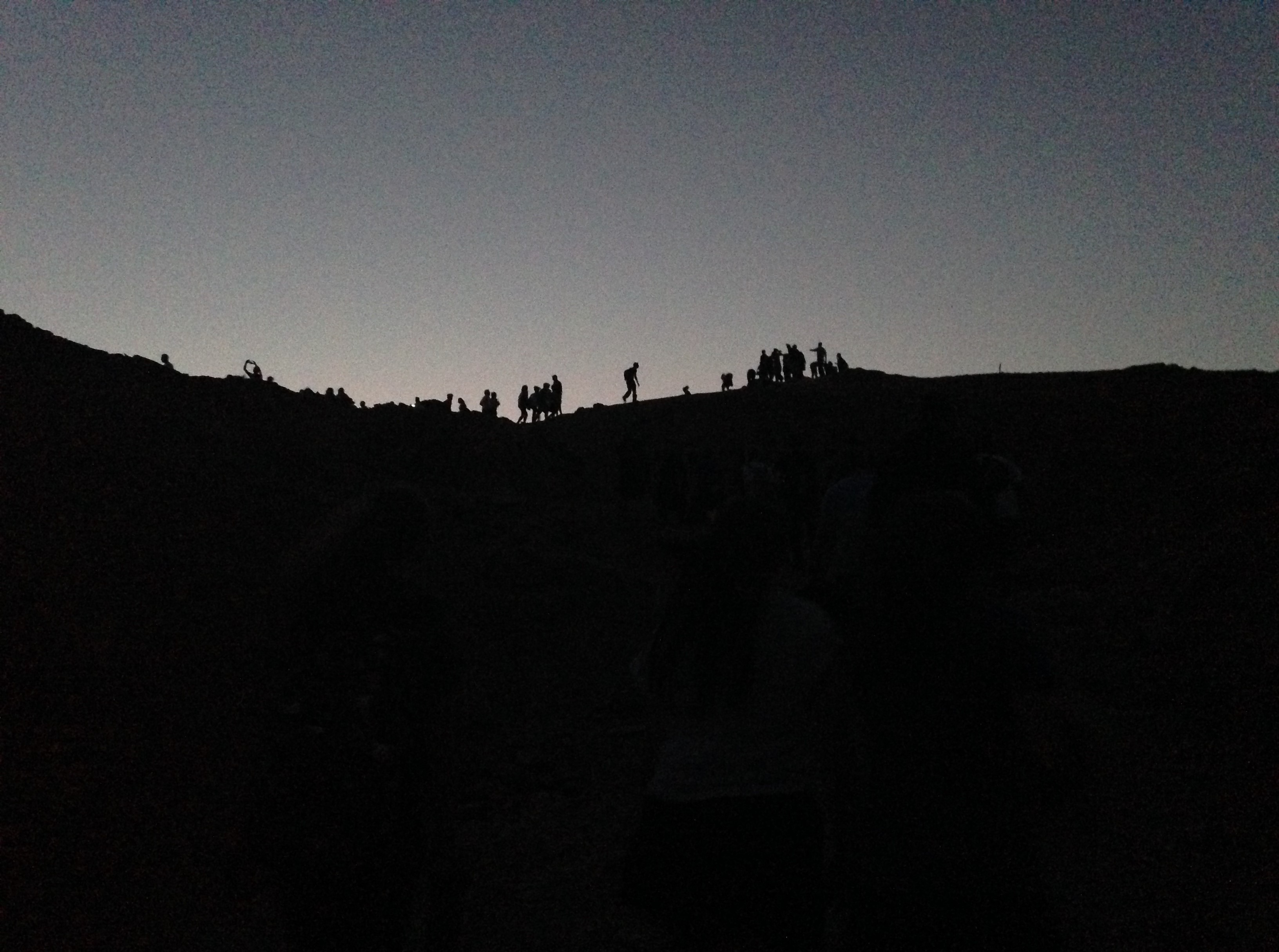 silhouette of people hiking in desert